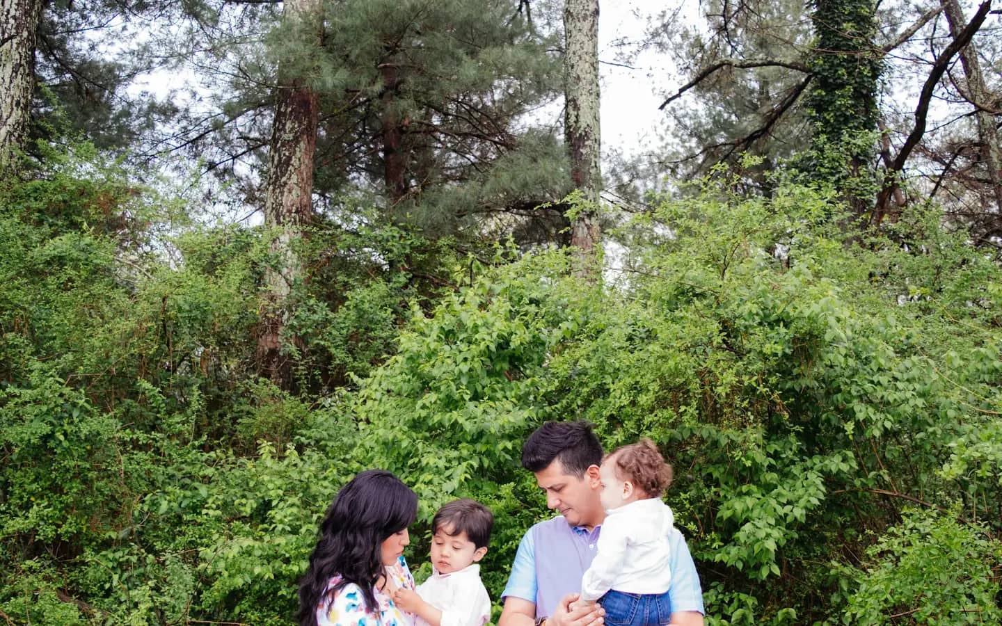 Parents holding their two young children outdoors