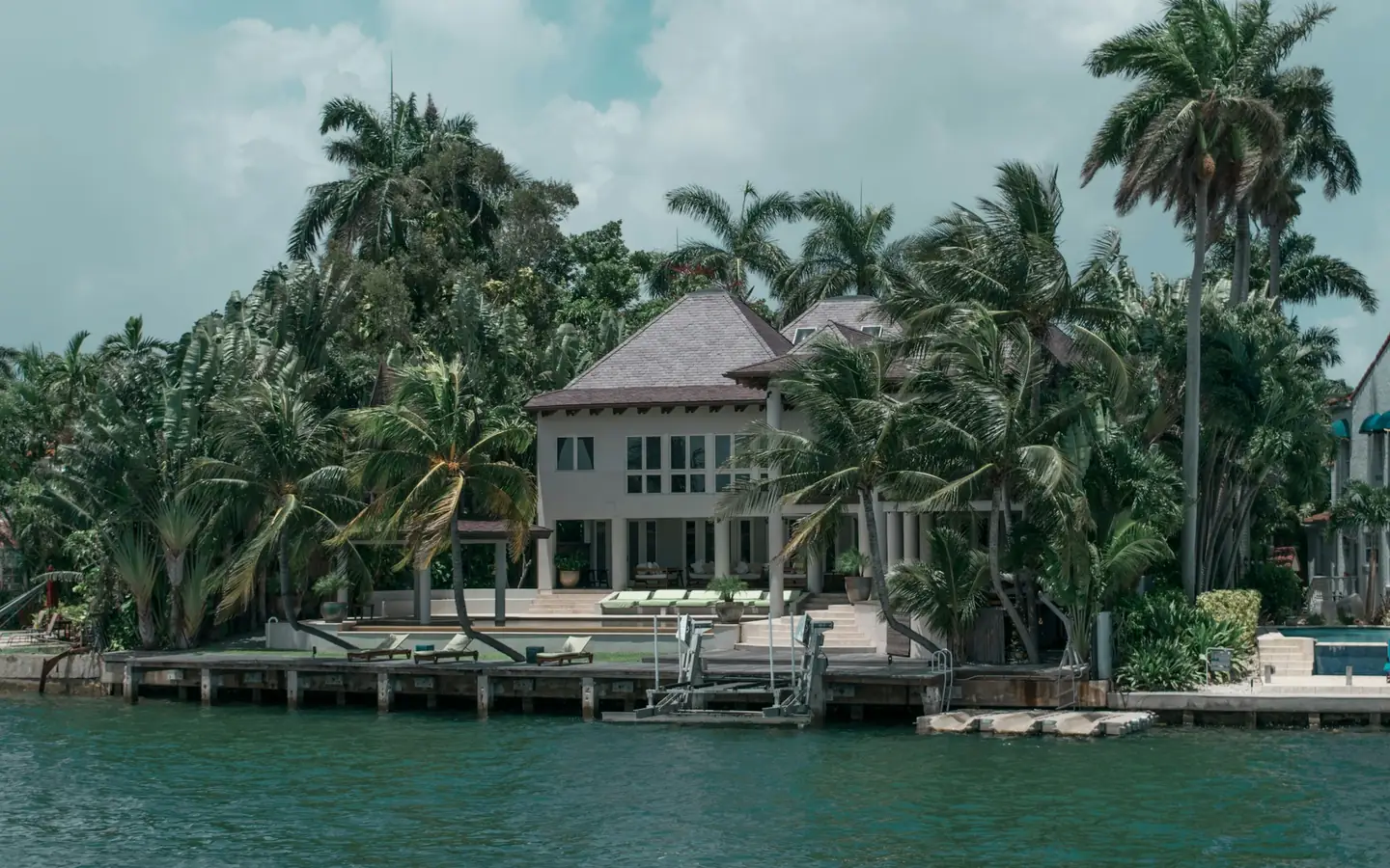 A waterfront house nestled among tropical trees